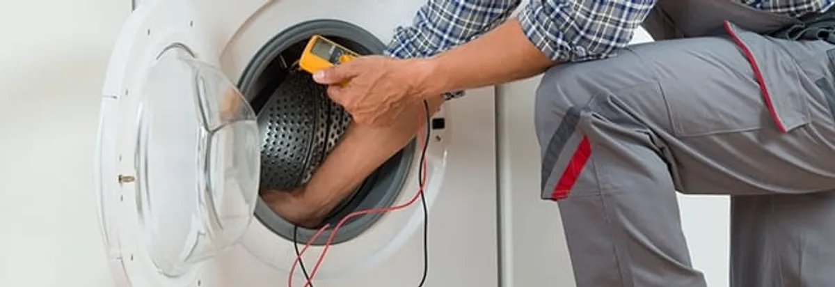 Dryer repair technician inspecting and repairing a clothes dryer in Raleigh, NC