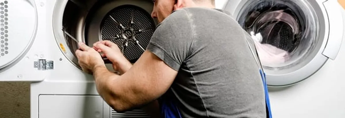 Dryer repair technician fixing a clothes dryer drum in Raleigh, NC