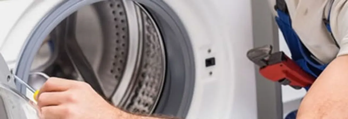 Appliance technician repairing a clothes dryer drum and internal parts in Raleigh, NC
