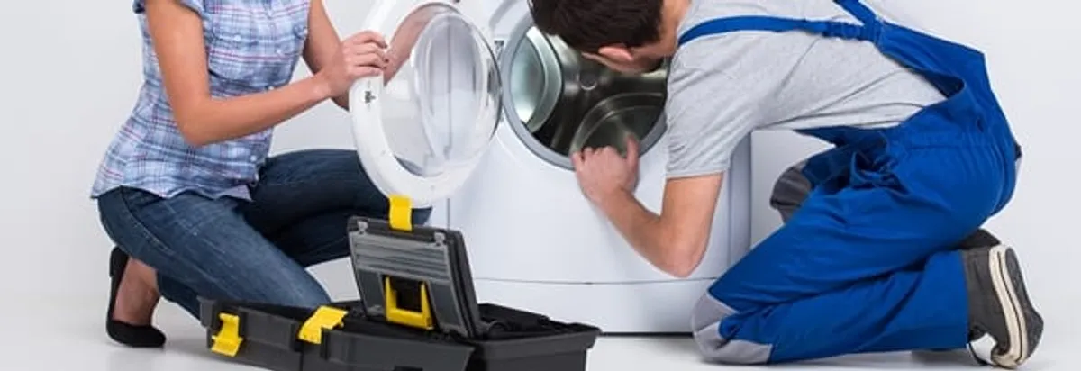 Washer repair technician inspecting a front-load washing machine with tools in Raleigh, NC