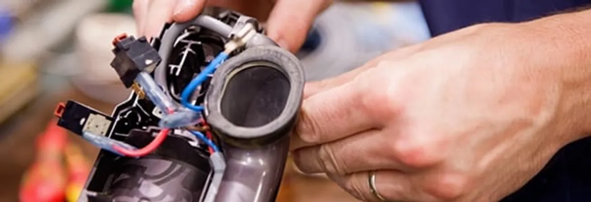 Vacuum repair technician reconnecting wiring and components in Raleigh, NC