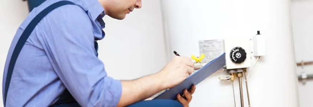 Water heater repair technician inspecting the unit and recording service notes in Raleigh, NC